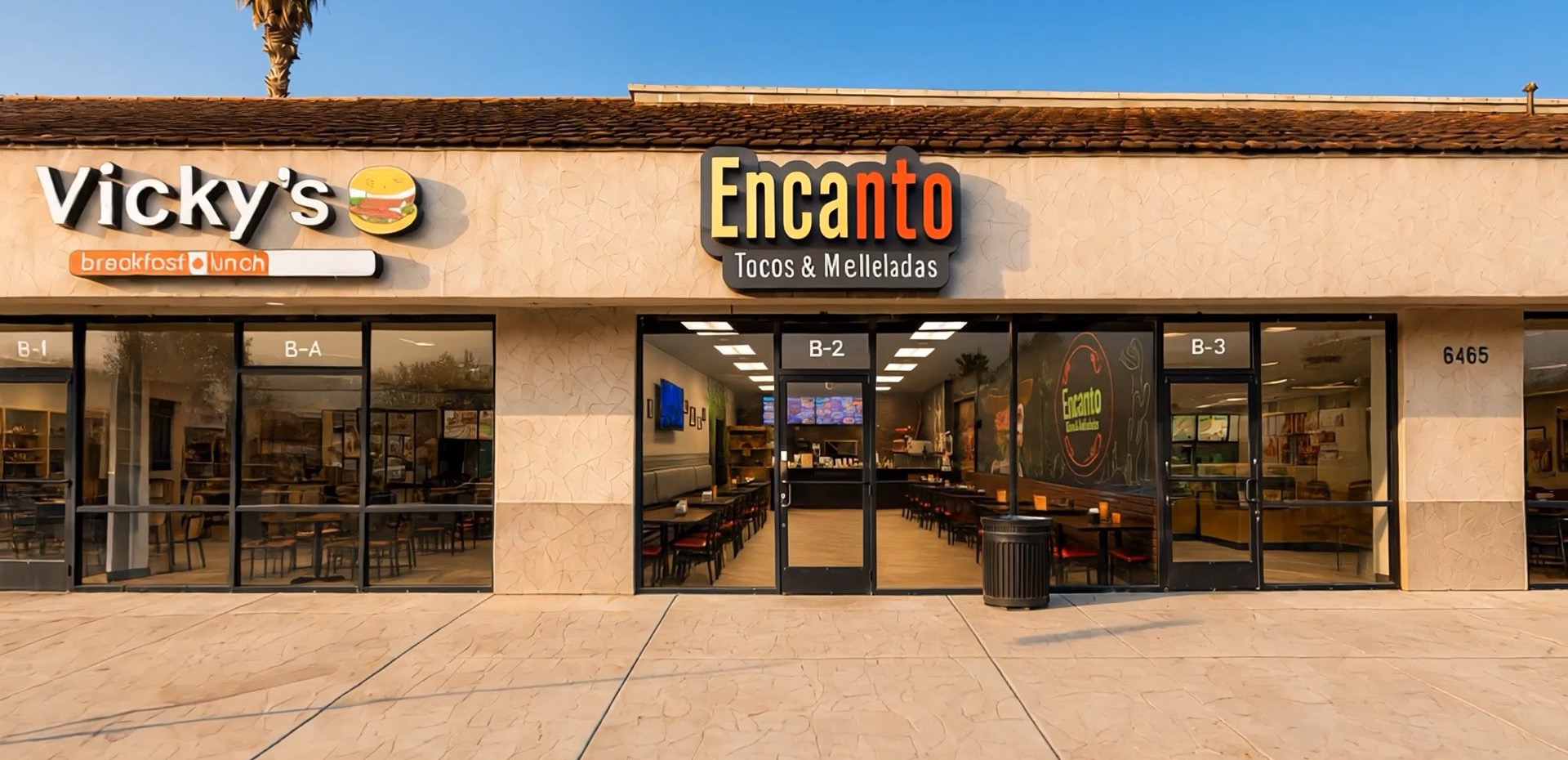 Encanto Tacos & Micheladas storefront at golden hour, with the dining room and counter visible through the open glass doors